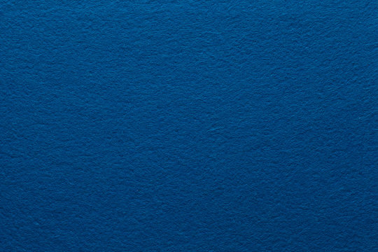 Dark blue felt texture abstract art background. Colored construction paper surface. Empty space.