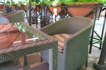 outdoor summer cafe with glass table and flower beds