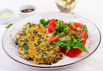 Baked steak chopped chicken fillet with spinach and a side dish of tomatoes salad. European cuisine. Dietary food.