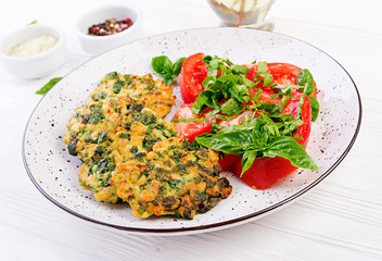 Baked steak chopped chicken fillet with spinach and a side dish of tomatoes salad. European cuisine. Dietary food.