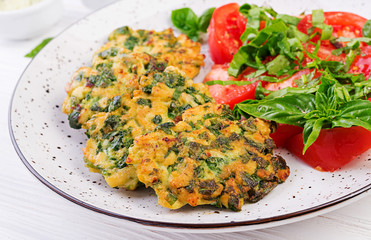 Baked steak chopped chicken fillet with spinach and a side dish of tomatoes salad. European cuisine. Dietary food.