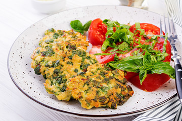 Baked steak chopped chicken fillet with spinach and a side dish of tomatoes salad. European cuisine. Dietary food.