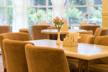modern restaurant interior with windows and flowers. cafe room illuminated by sunlight