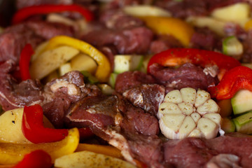 Raw beef meat with raw vegetables: zucchini, garlic, red and yellow pepper with natural spices and herb. Cook delicious dinner.  Healthy diet. Very tasty homely meal