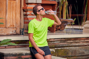 Sportsman making a pause with a bottle of water.