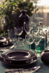 Closeup of black plate on dining room table covered with green tablecloth