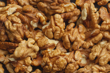 walnuts scattered on a black paper background