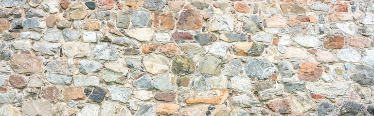 Stone wall texture. Colorful granite stone background. Old Vintage Stone Wall of Historical Medieval Castle in North Europe.  Banner. Header.  