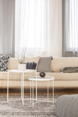 White industrial coffee tables in bright living room interior with big corner couch