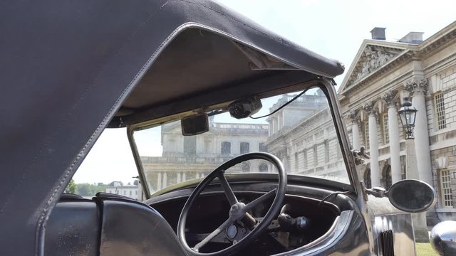 A view of an old building through a retro car windshield.