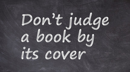 Obraz premium Don’t judge a book by its cover written on blackboard