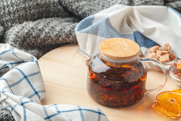 Earl Grey tea in glass tea pot on wood plate close up