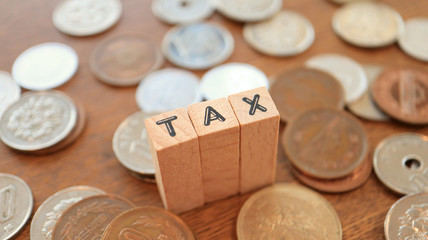 Wooden Text Block of Tax and Pile of Coins