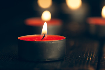 candles burning in darkness over black background. commemoration concept.