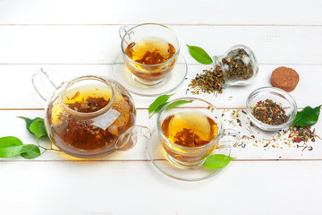 teapot and cups of tea on a white wooden background