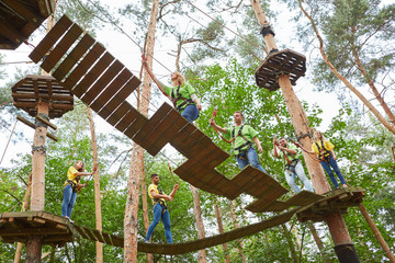 Gruppe überquert eine Bücke im Hochseilgarten