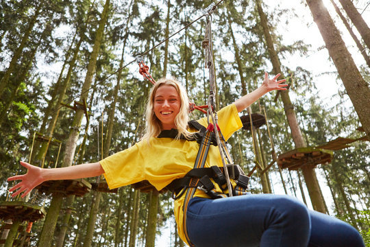 Junge Frau im Hochseilgarten hat Spaß - Powered by Adobe