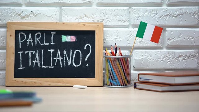 Do you speak Italian written on board, hand putting Italy flag in box, language