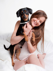 Woman in bed holding her dog.