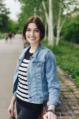 moderne junge frau mit jeansjacke im park