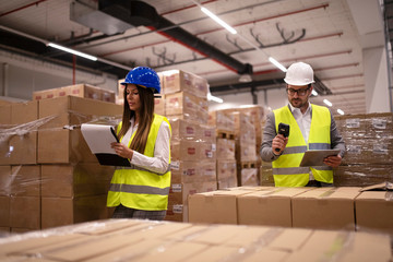 Working at warehouse. Employees with hardhat and reflective uniform controlling distribution. Male...