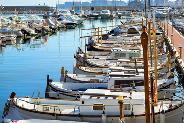 Private yachts and fishing boats moored at pier in seaport Blanes. Sailing and motor boats are moored at seawall. Vessels with catch of sea fish delicacies. Marina Blanes, Spain, Costa Brava