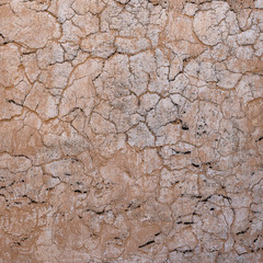 Cracked concrete old wall covered with beige cement surface as background. Textured background old cracked wall