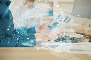 Social network theme hologram with businessman working on computer on background. Multi exposure.