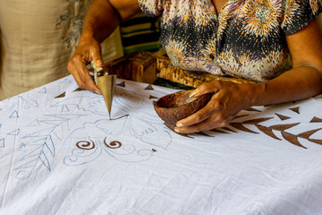 A local woman hand painting fabric in a local Batik fabric factory. The manufacture and export of...
