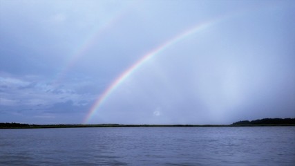 Fototapeta na wymiar double rainbow over the water