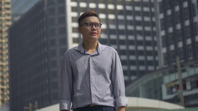 Portrait handsome businessman standing looking around urban city. Slow motion low angle shoot.