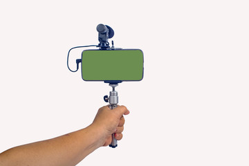streaming video live with smart phone and microphone tool in hand.