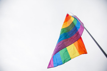A large gay pride rainbow flag at an LGBTQ gay pride march