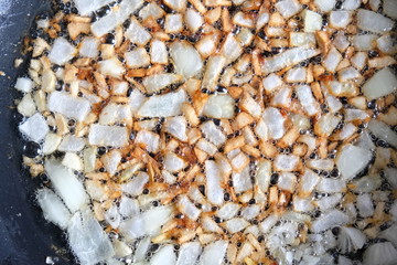 Onions and garlic being fried in a pan