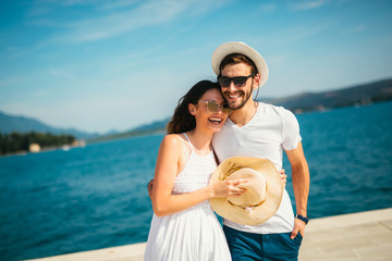 Young beautiful tourist couple enjoying summer holiday on the seaside