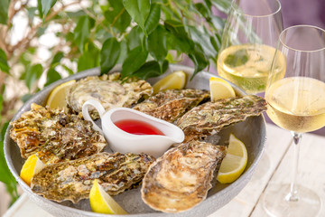 Fresh oysters with ice and white wine. Seafood. White background