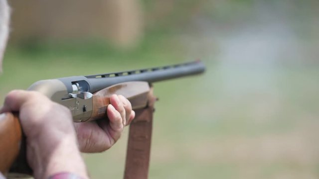 Hunting shotgun shooting and a cartridge case flying out breaching lock in slo-mo   