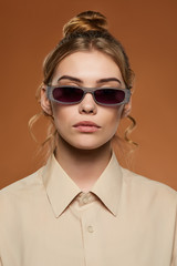 Cropped front view shot of blonde lady, wearing shirt. The girl with bun and wavy hair locks in...