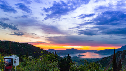 Camera capturing sunset shot. Photography using on tripod against sun rays with mountain in beautiful sundown scene.