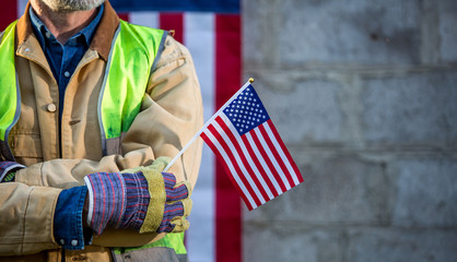 A serious worker man and american flag - obrazy, fototapety, plakaty