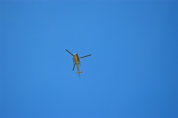 flying on a blue sky background a helicopter, view from below