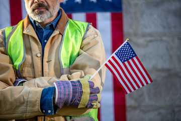 A serious worker man and american flag