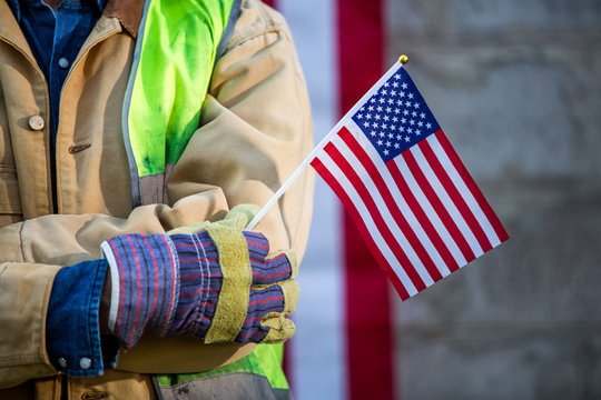A serious worker man and american flag - Powered by Adobe