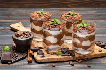 Classic tiramisu dessert in a glass on wooden background