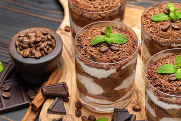 Classic tiramisu dessert in a glass on wooden background