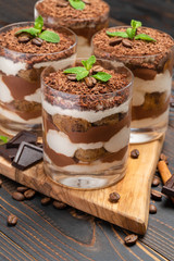 Classic tiramisu dessert in a glass on wooden background