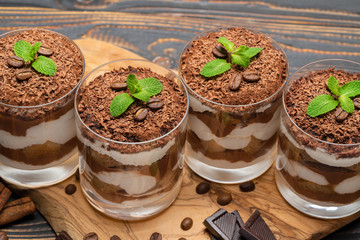 Classic tiramisu dessert in a glass on wooden background