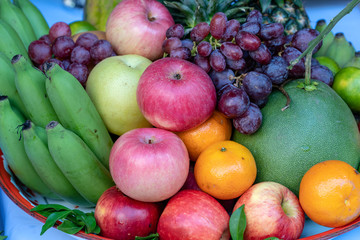 Assortment of fresh fruit banana, grapes, orange, apple, pineapple, tangerine and grapefruit on a tray. Closeup