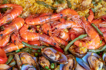 Spanish seafood paella in fry pan with mussels, shrimps and vegetables. Seafood paella background, closeup, traditional spanish rice dish