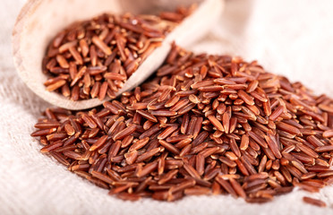 The brown rice with wooden spoon on sackcloth